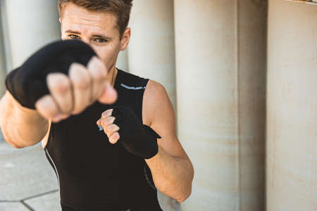 Man exercising and fighting in outside, boxer in gloves. male boxer portraitの写真素材