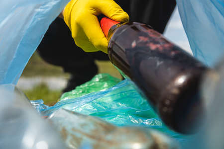 Close-up of a hand throwing garbage into a plastic bag. View from inside the bag. The concept of...