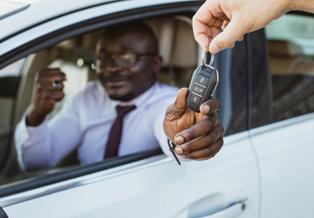 The concept of buying or renting a car. Close-up of handing over the keys. Car on lease. Buying a new vehicleの写真素材
