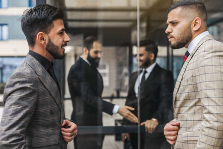 Business people outdoor meeting. Men in jackets discuss working moments together by brainstorming....