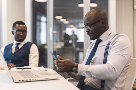 Two African American business partners are working on a laptop together on a joint project. Mutual assistance and establishment of social contactsの写真素材