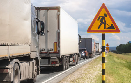 Trucks are stuck in traffic. A column of semi-trailers on the freeway. Road closures and road repairsの写真素材