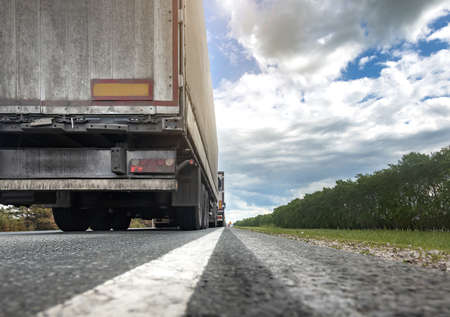 Trucks are stuck in traffic. A column of semi-trailers on the freeway. Concept of disruption in...