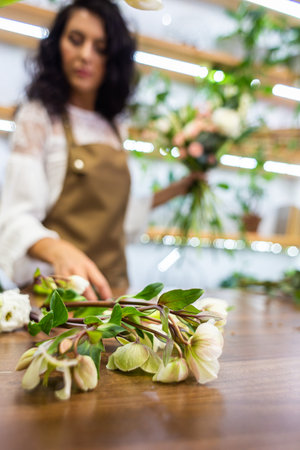 Attractive young woman florist is working in a flower shop.の写真素材