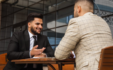 Business people outdoor meeting. Male employees in suits communicate outdoors. Business partners discuss and argue. Relationships and promotion. Teamwork and friendshipの写真素材