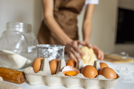 A woman in an apron prepares dough for baking at home. Rolling out and preparing dough for baking.の写真素材