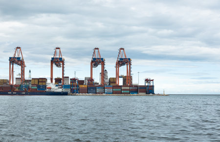 December 2, 2022 Mersin, Turkey: Operation of a large international cargo container port. Large cranes unload container ships and move cargo in a major seaport.のeditorial素材