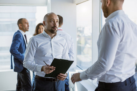 A team of young businessmen working and communicating together in an office. Corporate businessteam and manager in a meeting.の写真素材