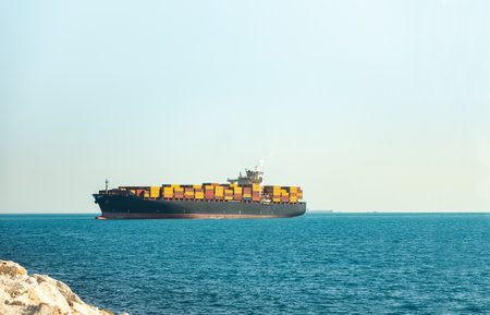 Large cargo container ship loaded with containers against the blue skyの写真素材