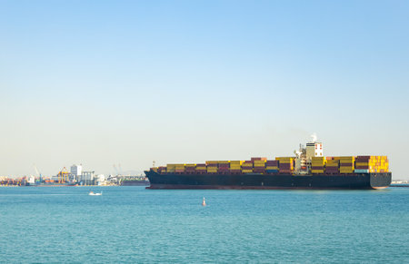 Large cargo container ship sails in the seaport