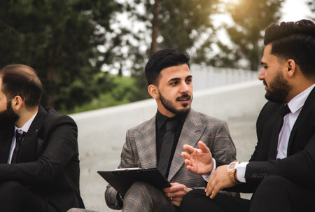 Business people outdoor meeting. Male employees in suits communicate outdoors. Business partners discuss and argue. Relationships and promotion. Teamwork and friendshipの写真素材