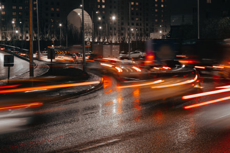 Evening car traffic in a big city. Cars in motion and standing in traffic jams. Long exposure exposure and headlight trailsの写真素材
