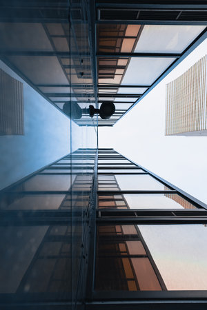 The geometry of modern urban architecture is reflected in the glass facades of buildingsの写真素材