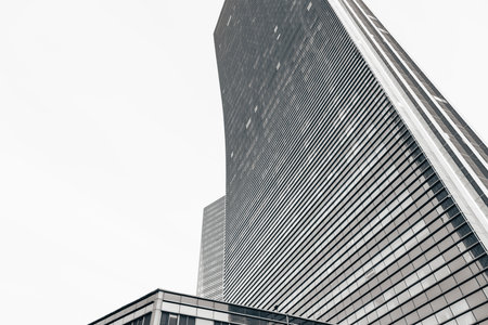 The geometry of modern urban architecture is reflected in the glass facades of buildingsの写真素材