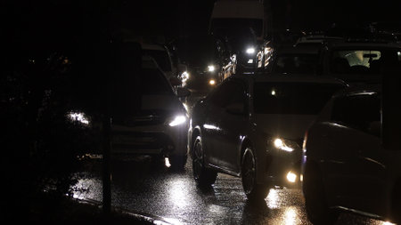 Evening car traffic in a big city. Cars in motion and standing in traffic jams. Long exposure exposure and headlight trailsの写真素材
