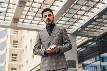 Portrait of a business man in suit outdoors against the backdrop of a glass building downtown.の写真素材