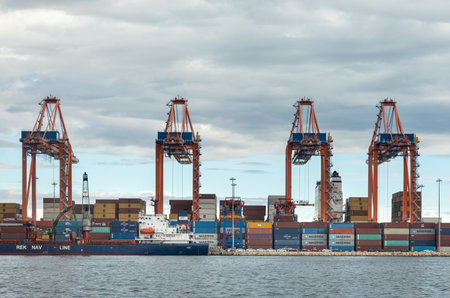 December 2, 2022 Mersin, Turkey: Operation of a large international cargo container port. Large cranes unload container ships and move cargo in a major seaport.のeditorial素材