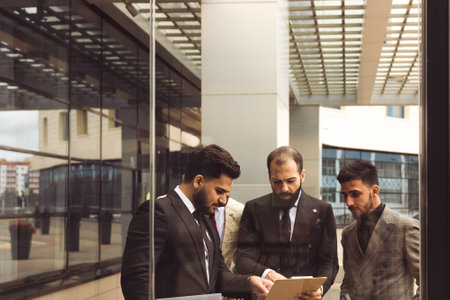 An international successful business team of male entrepreneurs in suits met to discuss development ideas. Efficient work and corporate spiritの写真素材