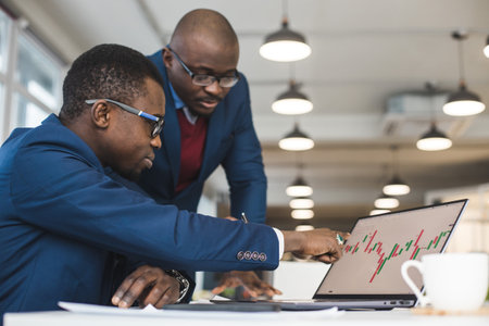 Two African American business partners are working on a laptop together on a joint project. Mutual assistance and establishment of social contactsの写真素材