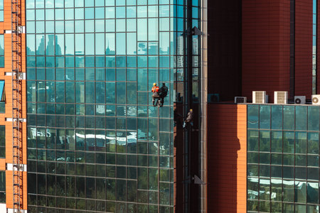 High-rise workers cleaning the windows of a skyscraperの写真素材