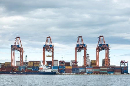 December 2, 2022 Mersin, Turkey: Operation of a large international cargo container port. Large cranes unload container ships and move cargo in a major seaport.のeditorial素材