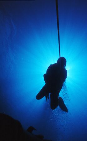 Silhouetted diver at a decompression stopの写真素材