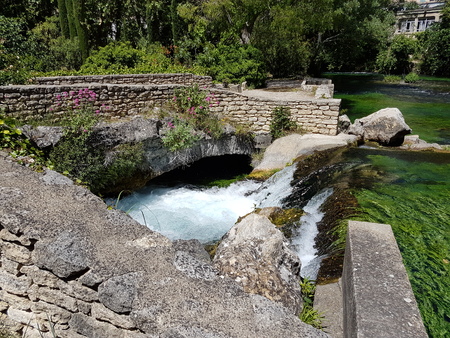 River flow with a small waterfall among the summer greens.の写真素材