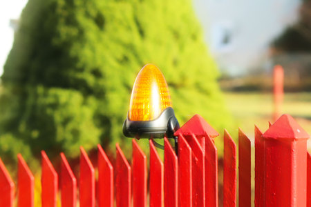 Orange room alarm light located on a brick fence post. Intercom apartment building at the entrance...