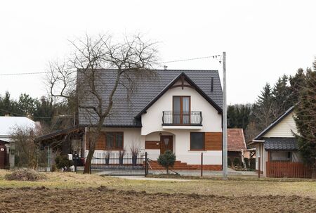 Jaslo, Poland - 9 2 2019: The project of a modern villa. Project of a small villa with clear walls and a brown roof. Rear and front courtyard of a private territory. Mastering new land and building.のeditorial素材