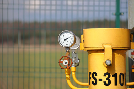 Pressure gauge for measuring the pressure of natural gas in a gas pipeline. Yellow transport pipes on the surface of the fence. Regulatory system for supplying natural compressed fuel. Accessの写真素材