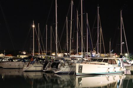Night parking of yachts in the Croatian ACI marina of the town of Jazira. Burning lights of the...