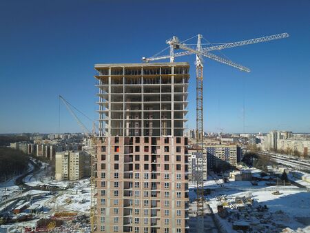 Tower cranes work during the construction of a multi-story building. New apartments for residents...