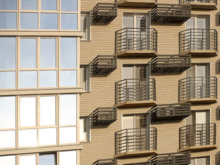 Lviv, Ukraine - 3 4 2020: Facade of a tall multi-storey modern house with balconies and large glass windows. Design of modern architecture. Top view from the bottom. Modern city architecture.のeditorial素材