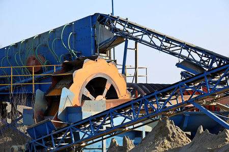 Elements of equipment for the extraction and sorting of rubble. Production of construction materials. Metal construction for working with stone and rocks. Slag of gravel under the conveyor belt.の写真素材
