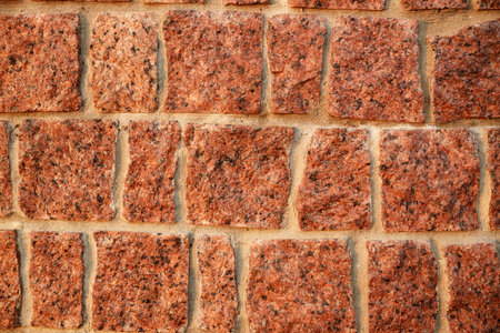 Brick texture of light red granite. Natural stone for construction. Decorative slabs. Natural...