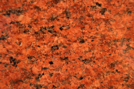 Texture of light red granite. Natural stone for construction. Decorative slabs. Natural background of polished granite chipsの写真素材