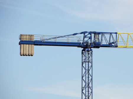 Tower cranes work during the construction of a multi-story building. New apartments for residents and premises for offices. Risky work at height. Lifting heavy building materials. City development.の写真素材