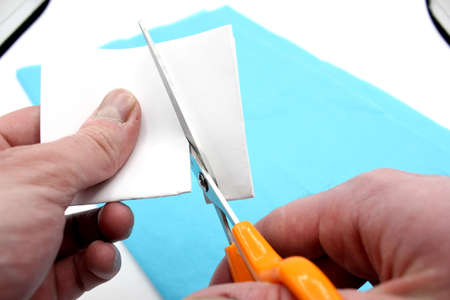 hands cutting paper with scissorsの写真素材