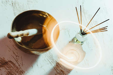 Zen still life with a Tibetan bowl, scents and a candle. Long exposure photography creating effect with candle light.の写真素材