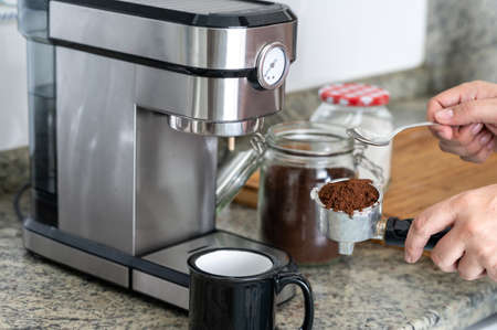 Making coffee at home with an espresso machine putting the coffee in the filterの写真素材