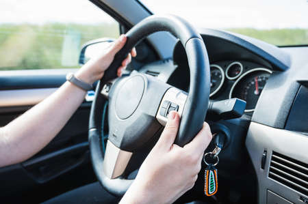 Unrecognizable young woman driving a car on a road trip.の写真素材