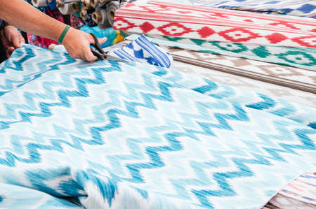 Man cutting a remnant from a roll of cloth. Majorcan LlengÃ¼esの写真素材
