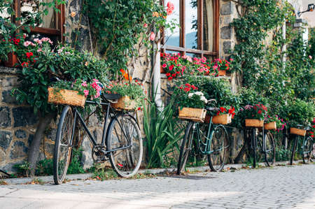 Bicycles in the street with flowers. Horizontal shot of a facade with bicyclesの写真素材