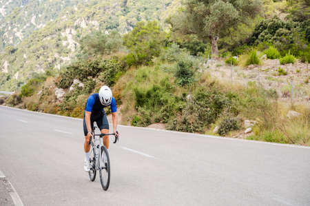 Unrecognizable cyclist climbing a mountain pass on a road bike in Majorcaの写真素材