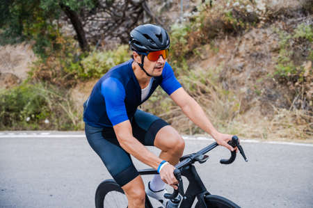 Cyclist riding up a mountain pass on a roadの写真素材