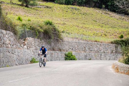 Senior cyclist climbing up a mountain passの写真素材