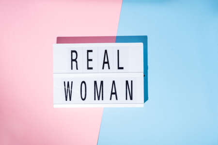 Real Woman text on the lightbox. Concept of feminism on a blue and pink background. Top viewの写真素材