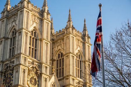 Westminster Abbey Gothic cathedral with British flag in London, United Kingdom