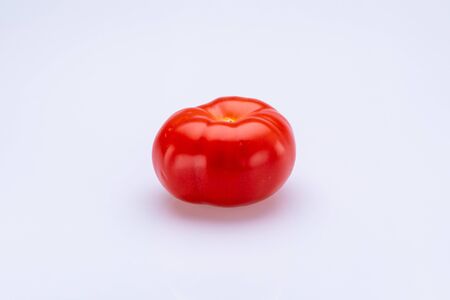 Red tomatoe sliced in half in front of a white backgroundの写真素材