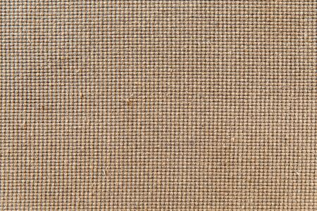 Close-up on the fabric covering an old sofa. The fabric is worn and has defects in some places. It...